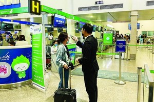 新山一機場人員為乘客測量體溫。