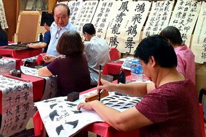 人民藝人書畫家張路在教學員寫書法。