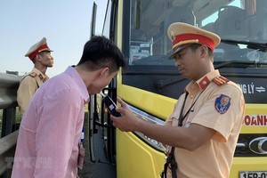 交警在給一名客車司機進行呼氣式酒精測試。（圖源：越通社）