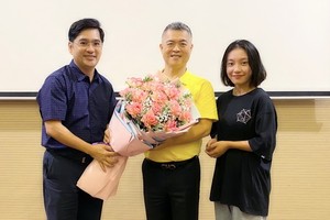 中文系副主任阮福祿送花給大發餅家總經理許玉林（中）。