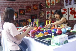 一名遊客在選購磨漆手工藝品。（圖源：俊德）