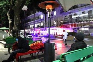 兩名病人家屬在取暖器周邊取暖。（圖源：黎富）