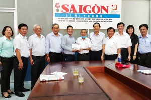 文忠孝編委（左五）接受王永勝理事長（右六）的捐款。