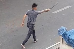 一名男子手持長劍在馬路上氣洶洶尋找對方“算賬”。（圖源：視頻截圖）