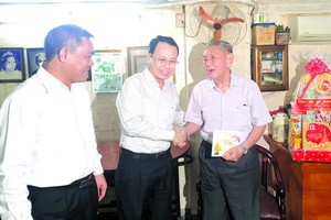 第五郡郡委書記阮文孝(中)親切問候華人退休幹部劉天雲。