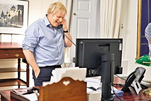 英國首相約翰遜23日和美國總統拜登通電話時笑逐顏開。（圖源：路透社）