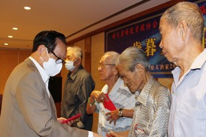 張豐裕先生（左一）同貧困老人分享自己八十大壽的喜悅。
