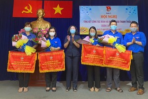 郡人民議會主席黃玉女芳紅(左三)、共青團第五郡郡委書記黎雄勇(右一)向各領先單位贈送錦旗。