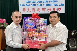 范興編委(左)接受丁文森贈送的新年禮物。