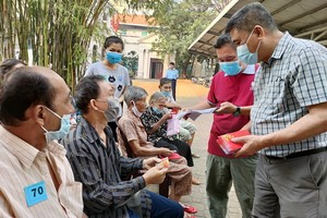 梁栢滔先生向華人貧病者贈送紅包。