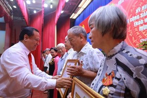 第十一郡郡委副書記陳飛龍（左）向各位高齡黨員頒授黨齡紀念章。（圖源：愛真）