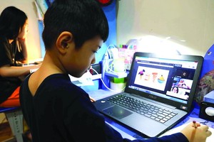 學生在家用電腦在線學習。