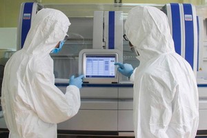 防疫工作人員在操作自動實時熒光定量自動檢測儀器。（圖源：VOH）