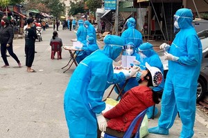 防疫工作人員對海陽省金城縣金蓮鄉的疫區居民進行鼻拭子取樣測試。（圖源：T. Thắng）