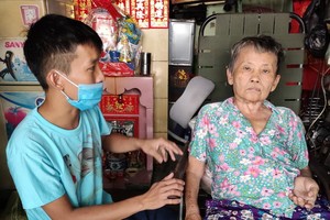 廖漢錦正照顧癱瘓的母親王桂英。