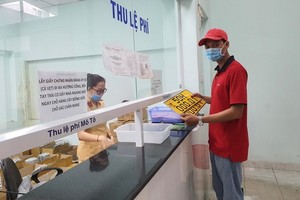 一名司機在市公安廳陸路與鐵路交通警察科辦事處換取黑子黃色車牌。（圖源：詩絨）