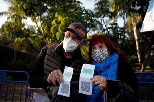 接種疫苗的老年人與綠色通行證合影。（圖源：互聯網）