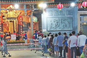 新冠肺炎疫情影響下，善信們排隊進廟內上香祈福。