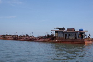 圖為一艘在芹耶河口流域上非法開採河沙的船隻。（圖源：勞動者報）