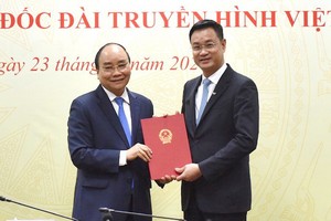 新任越南電視台總經理黎玉光（右）從阮春福總理手中接過人事委任《決定》。（圖源：陳海）