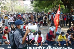 3月27日，緬甸仰光淡汶鎮抗議民眾佔領一條街道同軍警對峙。 （圖源：AP）