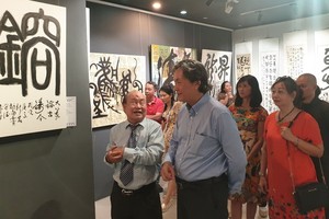 人民藝人張路書畫家(左一)向來賓介紹書法作品。