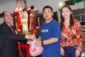 該廟理事長黃偉峰(左)向鄧奕波先生伉儷(右)轉交“觀音蓮花寶燈”。