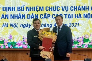 新任河內市高級人民法院院長阮春靖（左）領接人事委任《決定》。（圖源：C. Hùng）