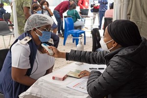 3月2日，工作人員在南非約翰內斯堡的一家醫院為前來接種新冠疫苗的醫護人員測量體溫。（圖源：新華社）