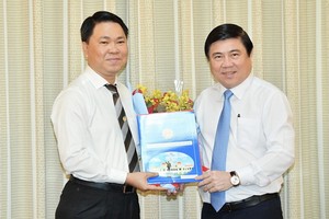 新任市建設廳長陳黃軍（左）從市人委會主席阮成鋒手中接過人事委任《決定》。（圖源：越勇）