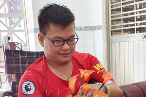 陳文雄拿著他親手做的假花。