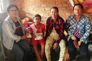 華人熱心人士何飛燕(左一)向石冬小朋友家庭轉交手術經費。