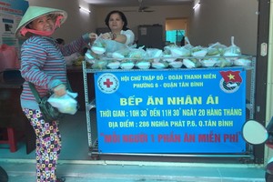 一名女性到“仁愛廚房”俱樂部領取慈善盒飯。