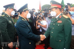 國防部部長潘文江上將（前右）與中國國防部部長魏鳳和上將互相握手致意。（圖源：越通社）