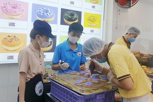 烘焙師按消費者要求製做甜甜圈。