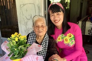 阮氏明心帶著學生的鮮花和信探望越南英雄母親陳氏近。