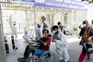 5月3日，醫務人員在印度艾哈邁達巴德的醫院內幫助新冠患者。（圖源：新華社）