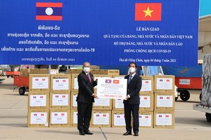 外交部副部長蘇英勇（右）在老撾萬象瓦岱國際機場向老撾副總理吉喬·凱坎匹吞轉交捐贈醫療物資並象徵性為老撾新冠肺炎疫情防控工作捐助50萬美元。（圖源：春山）