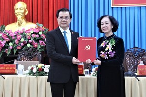 中央組織部長張氏梅（右）向黎鴻光同志（左）頒發黨中央政治局調動與分工出任2020-2025年任期安江省委書記職務《決定》。（圖源：越通社）