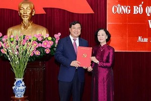 范嘉足同志（左）從中央組織部長張氏梅手中接過人事委任《決定》。（圖源：春秋）