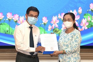 阮文勇同志（左）從市人民議會主席阮氏麗手中接過人事委任《決定》。（圖源：雪民）