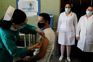 哈瓦那一名年輕志願者接種本土候選冠病疫苗“主權02”。（圖源：AFP）