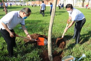 市委原書記阮善仁（左）與平新郡郡委書記黎文聲一同在平治東B坊25號街的公園參加植樹活動。（圖源：喬峰）