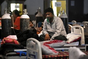 5月8日，新冠患者在印度新德里的一處隔離中心吸氧。（圖源：新華社）