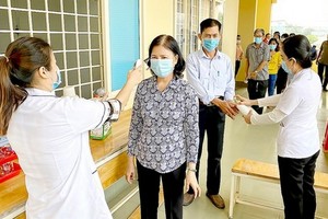 在參加接觸國會代表候選人會議前，古芝縣選民獲量體溫，用殺菌液洗手。