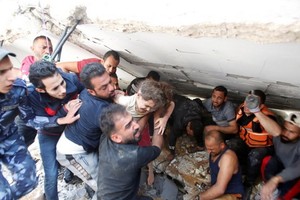 救援人員從一處空襲廢墟中搶救出一名六歲的女童。（圖源：路透社）