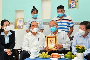 國家主席阮春福（前左二）看望榮軍黎文高。（圖源：越勇）