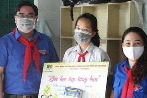 值市少年先鋒隊成立80週年，市共青團副書記吳明海向清貧隊員贈送學習角。