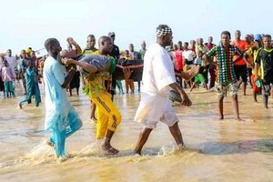 船禍發生後，人們將遇難者屍體撈上岸並送去辦理後事。（圖源：AFP）