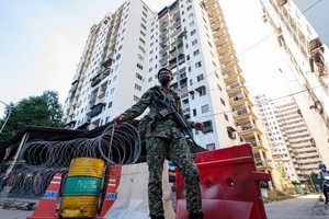士兵在吉隆坡市郊一處因新冠疫情被封鎖的社區執勤。（圖源：新華社）